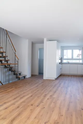 Essbereich mit Stahltreppe links und Küche im Hintergrund