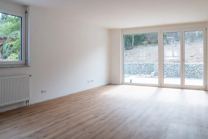 Wohnbereich mit dreiteiliger bodentiefer Fenstertür zur Terrasse, Sonne auf dem Boden
