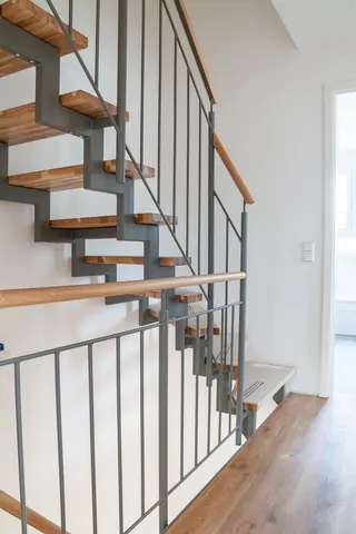 Stahltreppe mit Holzstufen und Stabgeländer