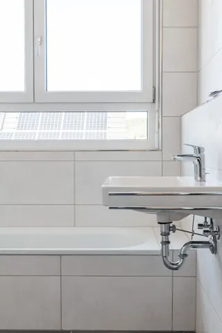 Waschtisch und Badewanne vor dem Badfenster